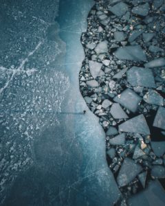 A lonely person on a lip in the Baltic Sea on the coast of Turku, Finland. The ice floes are created by the passage of ferries and ships A lonely person on a lip in the Baltic Sea on the coast of Turku, Finland. The ice floes are created by the passage of ferries and ships