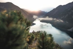 Sunrise over the Plansee in Austria taken from a hunter's path with a woman in the background Sunrise over the Plansee in Austria taken from a hunter's path with a woman in the background