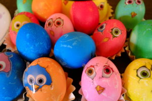 Colored Easter eggs with stickers looking like freshly hatched chickens Colored Easter eggs with stickers looking like freshly hatched chickens