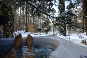 Man's feet sticking out of outdoor hot tub during winter Man's feet sticking out of outdoor hot tub during winter