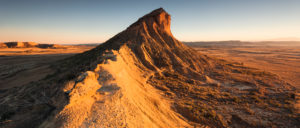 Panoramaaussicht von Bergen in der Wüste Bardena Reales zum Sonnenuntergang in gleisendem Licht, Navarra, Spanien Panoramaaussicht von Bergen in der Wüste Bardena Reales zum Sonnenuntergang in gleisendem Licht, Navarra, Spanien