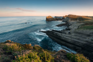 Playa Romantica near Liencres in Cantabria / Spain at sunrise, bathed in warm light of the first rays