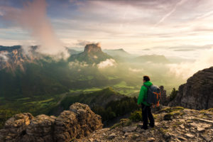 Hiker with far sight on sunrise over Mont Aiguille, Dauphine, France