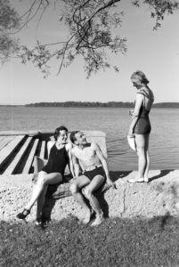 Two young women and a young man sunbathing and swimming in the Chiemsee, Dermany 1930s. Two young women and a young man sunbathing and swimming in the Chiemsee, Dermany 1930s.