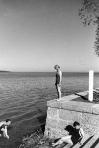 Two young women and a young man sunbathing and swimming in the Chiemsee, Dermany 1930s. Two young women and a young man sunbathing and swimming in the Chiemsee, Dermany 1930s.