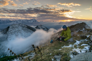 Deutschland, Bayern, Bayerische Alpen, Garmisch-Partenkirchen, Oberer Rißkopf, Wanderer kocht Kaffee auf Berg mit Blick auf die Zugspitze während des Sonnenuntergangs Deutschland, Bayern, Bayerische Alpen, Garmisch-Partenkirchen, Oberer Rißkopf, Wanderer kocht Kaffee auf Berg mit Blick auf die Zugspitze während des Sonnenuntergangs