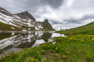 Deutschland, Bayern, Allgäu, Oberstdorf, Person steht vor Bergkulisse am Rappensee Deutschland, Bayern, Allgäu, Oberstdorf, Person steht vor Bergkulisse am Rappensee