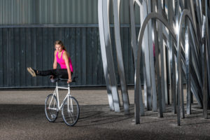 Woman, 19 years old, cycling with artificial wheel, outdoors Woman, 19 years old, cycling with artificial wheel, outdoors