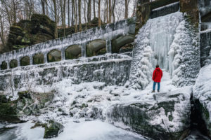 Hiker with red jacket in winter, aqueduct, Saxon Switzerland, snow, waterfall Hiker with red jacket in winter, aqueduct, Saxon Switzerland, snow, waterfall
