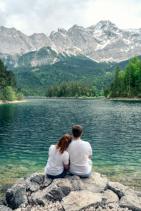 A couple in love sits at the Eibsee in Bavaria. In the background you can see the Zugspitze. A couple in love sits at the Eibsee in Bavaria. In the background you can see the Zugspitze.