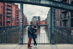 A couple is in Hamburg in front of the Speicherstadt and kisses. A couple is in Hamburg in front of the Speicherstadt and kisses.