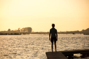 Young man on a jetty in sunset Young man on a jetty in sunset