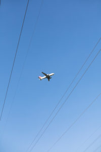 Flugzeug am Himmel, darunter: Stromkabel Flugzeug am Himmel, darunter: Stromkabel