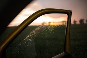 Blick durch eine heruntergelassene Autoscheibe auf die Landschaft nach einem Gewitter Blick durch eine heruntergelassene Autoscheibe auf die Landschaft nach einem Gewitter