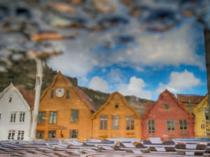 Houses reflecting in a puddle in Bergen, Norway, historic row of houses at the harbor, Tyske Brygge in Bergen, Norway Houses reflecting in a puddle in Bergen, Norway, historic row of houses at the harbor, Tyske Brygge in Bergen, Norway