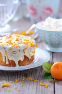 Small orange cake with white icing on plate Small orange cake with white icing on plate