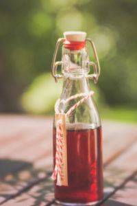 Glass bottle with homemade raspberry vinegar Glass bottle with homemade raspberry vinegar