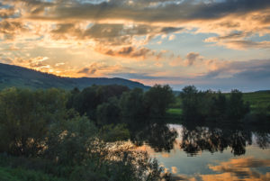 view to the Mosel and the vineyards behind it, close Trittenheim, partly clouded and illuminated sky in the evening. view to the Mosel and the vineyards behind it, close Trittenheim, partly clouded and illuminated sky in the evening.