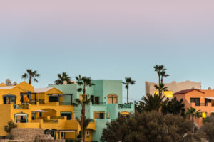 Colorful housing complex with palm trees in front of a evening sky at the coast of Tenerife. Colorful housing complex with palm trees in front of a evening sky at the coast of Tenerife.