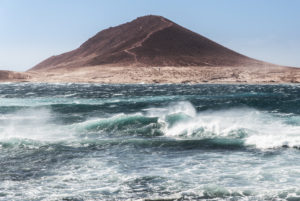 The volcano Montana Roja on Tenerife with the storm-lashed bay of El Medano in the foreground. The volcano Montana Roja on Tenerife with the storm-lashed bay of El Medano in the foreground.