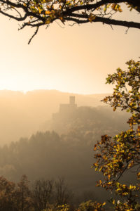 Hilly landscape with the castle Pyrmont in the center of the picture flooded by the rays of the setting sun. Hilly landscape with the castle Pyrmont in the center of the picture flooded by the rays of the setting sun.