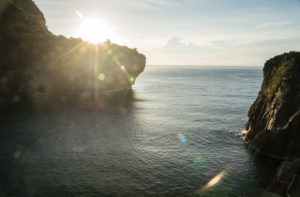 Bay with high rocks at sunrise and sunrays, sea, morning mood, untouched day Bay with high rocks at sunrise and sunrays, sea, morning mood, untouched day