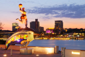 Sculpture by Niki de Saint Phalle on the banks of the Elbe with a view of St. Pauli Landungsbrücken in the evening light, Hamburg, Elbe, Hanseatic City, Port of Hamburg, Germany Sculpture by Niki de Saint Phalle on the banks of the Elbe with a view of St. Pauli Landungsbrücken in the evening light, Hamburg, Elbe, Hanseatic City, Port of Hamburg, Germany