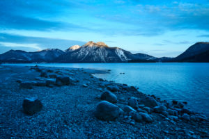 Drone recording of the Walchensee in Bavaria in November, morning mood, glassy water and the first snow on the trees