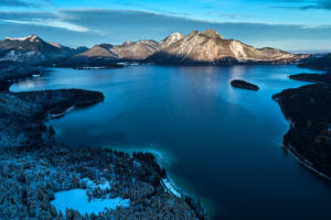 Drone recording of the Walchensee in Bavaria in November, morning mood, glassy water and the first snow on the trees