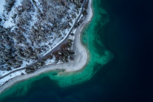 Drone recording of the Walchensee in Bavaria in November, morning mood, glassy water and the first snow on the trees