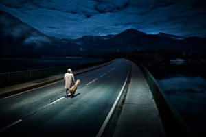 Night photography of a lonesome guitarist on the Sylvensteinsee bridge in the Upper Bavarian Voralpen                          