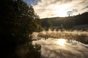 Late-summery morning mood with deep early fog over the forest pond in Dietramszell, Bavaria