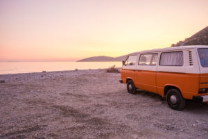 An orange and white VW Bus "Bulli" stands at sunset on the beach of the Ionian Sea near Saranda (Sarandë), Albania. An orange and white VW Bus "Bulli" stands at sunset on the beach of the Ionian Sea near Saranda (Sarandë), Albania.