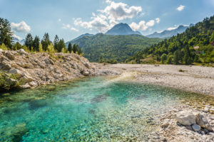 In the Valbona river, ice cold, turquoise crystal clear water flows into the valley. Valbona (Valbonë), Kukës, Albania. In the Valbona river, ice cold, turquoise crystal clear water flows into the valley. Valbona (Valbonë), Kukës, Albania.
