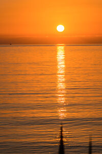 The sun sets in orange light over the Mediterranean near Sicily.