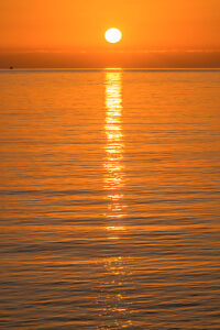 The sun sets in orange light over the Mediterranean near Sicily.