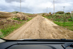 View from the cockpit of a camper on a narrow and very bad, dilapidated country road. Sicily, Italy.