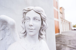 A marble figure of an angel in front of the pilgrimage church with the famous Black Madonna of Tindari (Messina), Sicily, Italy.