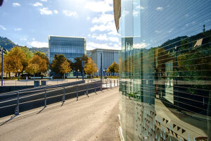 On a sunny fall day, the Kunsthaus Bregenz is reflected in a glass façade. Bregenz, Vorarlberg, Austria.