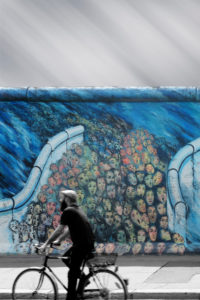 Streetart photography of a cyclist in front of a painting of the East Side Gallery, Streetart photography of a cyclist in front of a painting of the East Side Gallery,