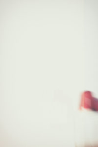 A blurry red warning light with loudspeaker throw shadows on a white wall, A blurry red warning light with loudspeaker throw shadows on a white wall,