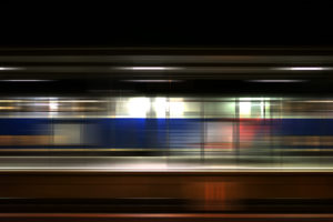 Platform of Weinheim station at night, seats at glass partition wall, passing train Platform of Weinheim station at night, seats at glass partition wall, passing train