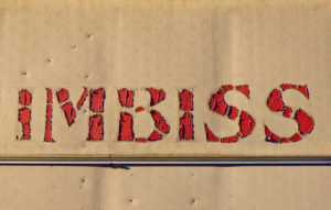 Schriftzug ' Imbiss ', rote Buchstaben auf beigem Hintergrund Schriftzug ' Imbiss ', rote Buchstaben auf beigem Hintergrund