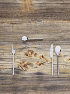 Instruments, knife, fork and spoon, laid on old wooden table, from above Instruments, knife, fork and spoon, laid on old wooden table, from above
