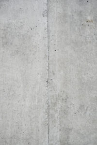 Beton grau Wand mit Struktur und Einschlüssen als Hintergrund Beton grau Wand mit Struktur und Einschlüssen als Hintergrund