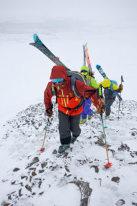 Mountaineers carrying skis to freeride downhill in Akureyri, Fjord Eyjafjördur, Nordland, Iceland