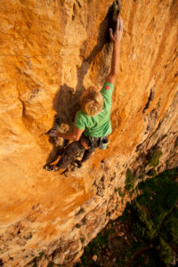 Climber in the rock faces of Monte Monaco at Capo San Vito, Sicily, Italy