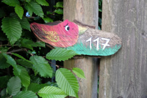 House number plate with bird motif on the wooden fence House number plate with bird motif on the wooden fence
