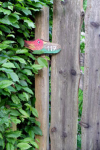 House number plate with bird motif on the wooden fence House number plate with bird motif on the wooden fence