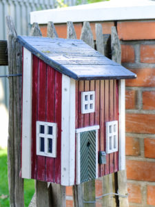 Briefkasten am Zaun aus Holz im Stil eines typischen Schwedenhauses Briefkasten am Zaun aus Holz im Stil eines typischen Schwedenhauses